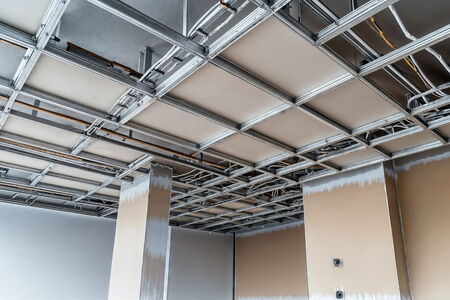 Montage einer abgehängten Decke im Trockenbauverfahren Innenaufnahme eines Raumes im Ausbauzustand mit sichtbar montierter Metall-Unterkonstruktion für eine abgehängte Decke, teilweise bereits mit Platten bestückt